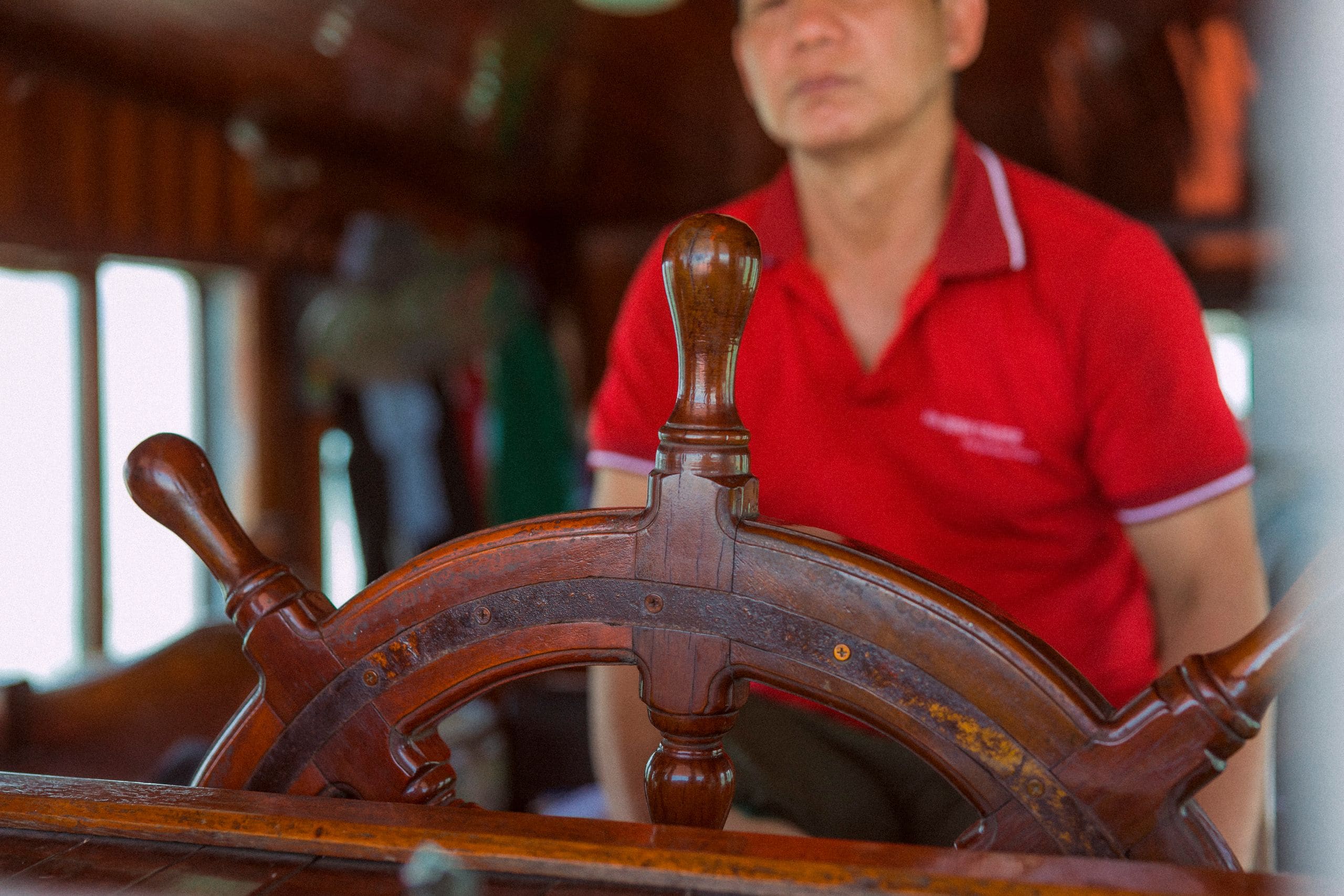 A veteran captain at the helm sharing a laugh with guests aboard a charter cruise
